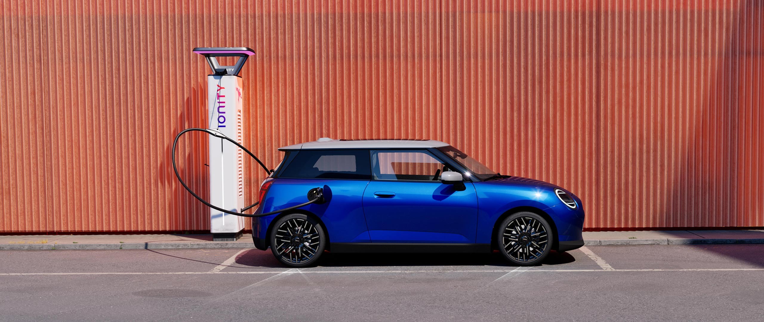 MINI Cooper Elettrica vista di lato davanti a una stazione di ricarica IONITY